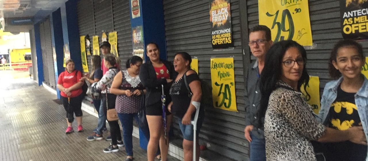 Consumidores acordam cedo, pegam chuva e enfrentam fila