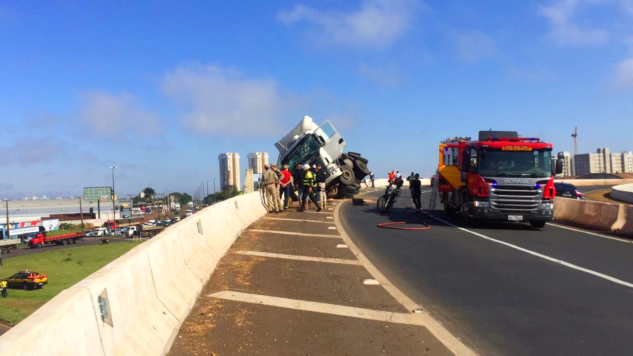 Carreta tomba sobre mureta, por pouco não cai debaixo de viaduto