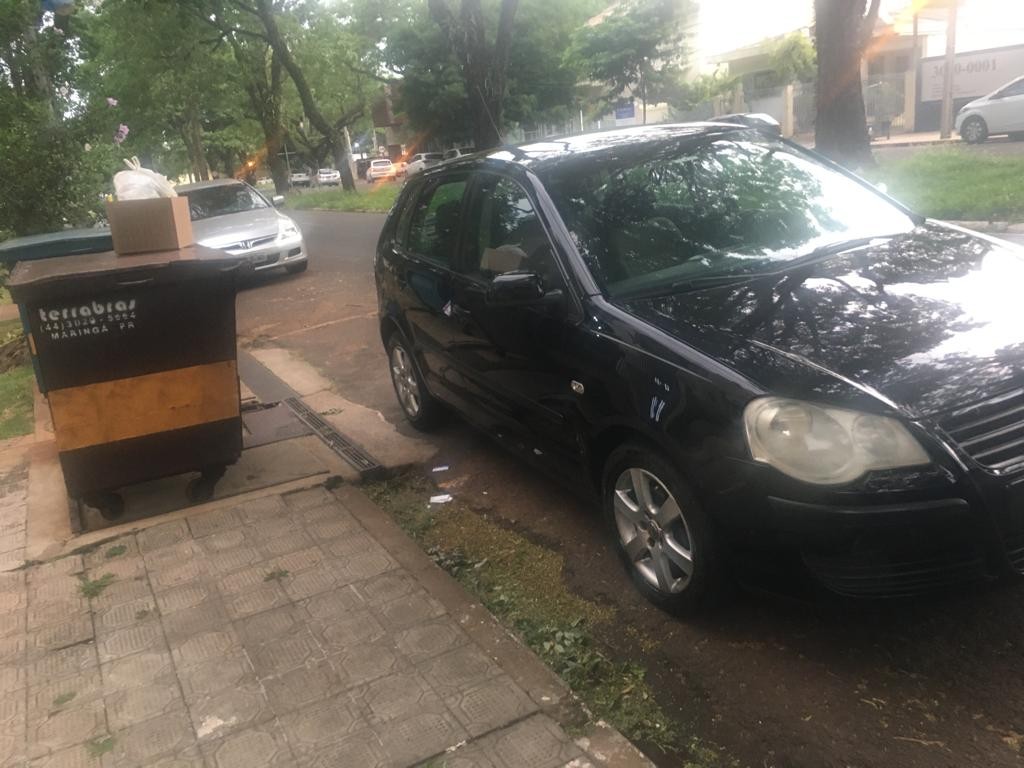 Carro estacionado em frente ao contêiner de lixo, impedindo a coleta