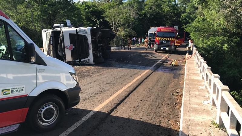 Caminhão tomba em cima de ponte e motorista fica ferido